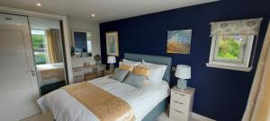 a bedroom with blue walls and a bed with pillows at The Causeway in Bracadale