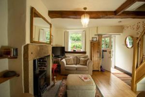 a living room with a couch and a fireplace at Characterful 2 bed cottage in excellent location in Baslow