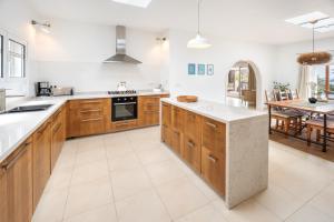 a large kitchen with wooden cabinets and a table at Lanzahost Villa Panorama in Mácher