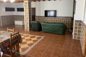 a living room with a couch and a tv at El-cortijo in Siete Aguas