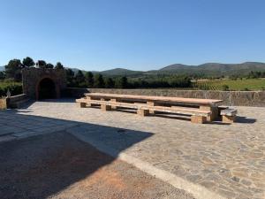 un gruppo di panche di legno sedute di fronte a una galleria di El-cortijo a Siete Aguas