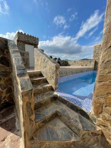 una escalera de piedra que conduce a una piscina en El-cortijo en Siete Aguas