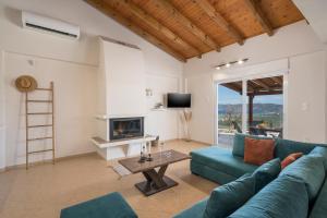 a living room with a blue couch and a fireplace at Villa Cleronomia, private pool, seaview, in Kaloudhianá