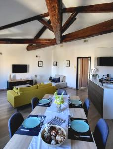 a dining room with a table and a couch at Le Repaire du Soleil in Aigues-Mortes