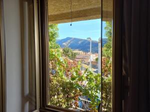 een raam met uitzicht op een berg bij The Englishmans Home in Cuglieri