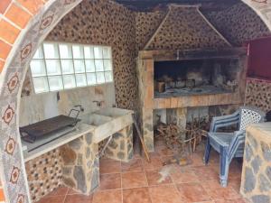 a kitchen with a fireplace and a stove in a room at El-cortijo in Siete Aguas