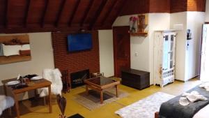 uma sala de estar com lareira e televisão em Chales Sabor Dos Ventos em Gonçalves