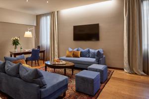 un soggiorno con divano blu e tavolo di Hotel Accademia a Verona