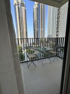 a balcony with a table and chairs and tall buildings at Magnolia- Dubai Creek Harbour Condo Apartment ApartHotel UAE in Dubai