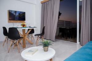 uma sala de estar com uma mesa e cadeiras e um sofá em Wink Bnb Paraliaki em Kissamos