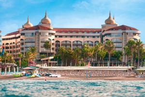 a large building on the beach in front of the water at Kirman Arycanda De Luxe in Okurcalar