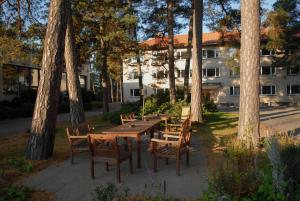 een houten tafel en stoelen met bomen en een gebouw bij Hotel Sofia in Helsinki