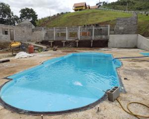 ein großer Pool mit blauem Wasser im Hof in der Unterkunft Chales Sabor Dos Ventos in Gonçalves