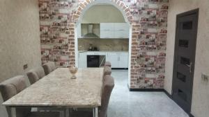 cocina con mesa con sillas y pared de ladrillo en Villa Novxani, en Baku