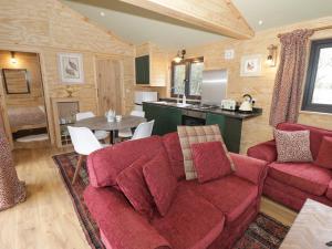 a living room with a red couch and a table at Willow in Rugby