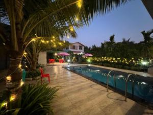 a pool at night with lights and a resort at iIRA Stays-Awas Beach Resort - Pet Friendly in Alibaug