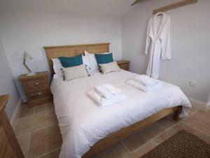 una camera da letto con un grande letto bianco con asciugamani di Pass the Keys Stunning cottage close to city centre a Bath