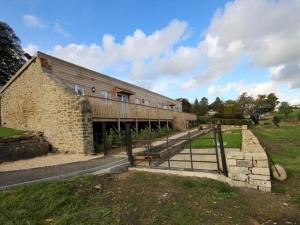 un vecchio edificio in pietra con una recinzione in un campo di Pass the Keys Stunning cottage close to city centre a Bath