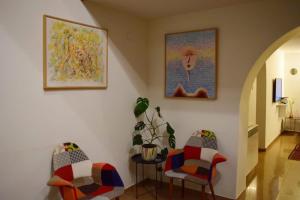 a hallway with two chairs and a table with a plant at Hestia - Hotel, Wine and View in Tʼelavi