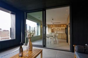 uma sala de estar com janelas grandes e uma mesa em Les Terrasses de Sainte Waudru em Mons