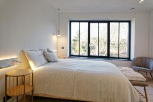 een slaapkamer met een groot bed en een groot raam bij Les Terrasses de Sainte Waudru in Bergen