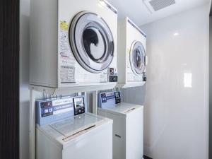 two washing machines and a washer and dryer in a room at Hotel Wing International Premium Osaka-Shinsekai in Osaka