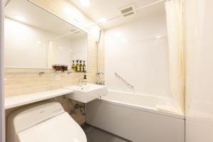 a bathroom with a toilet and a sink and a tub at Hotel Wing International Premium Osaka-Shinsekai in Osaka