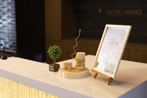 a table with a sign and a plant on it at Hotel Wing International Premium Osaka-Shinsekai in Osaka