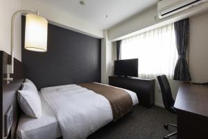 a hotel room with a bed and a window at Hotel Wing International Premium Osaka-Shinsekai in Osaka