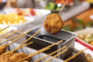 a meat ball on a stick in a tray of food at Hotel Wing International Premium Osaka-Shinsekai in Osaka