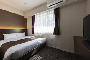 a hotel room with a bed and a window at Hotel Wing International Premium Osaka-Shinsekai in Osaka