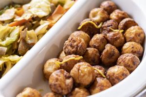 a white dish filled with meatballs next to a salad at Hotel Wing International Premium Osaka-Shinsekai in Osaka