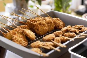 a bunch of fried food on a grill with sticks at Hotel Wing International Premium Osaka-Shinsekai in Osaka