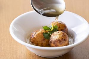 a white bowl with two meatballs with a spoon at Hotel Wing International Premium Osaka-Shinsekai in Osaka