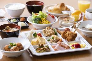 a table with plates of food on a table at Hotel Wing International Premium Osaka-Shinsekai in Osaka