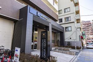 a building with a sign in front of it at Hotel Wing International Premium Osaka-Shinsekai in Osaka