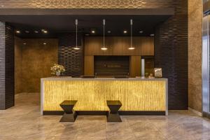 a lobby with a counter with two stools at Hotel Wing International Premium Osaka-Shinsekai in Osaka