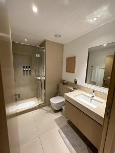 a bathroom with a toilet and a sink and a shower at Magnolia- Dubai Creek Harbour Condo Apartment ApartHotel UAE in Dubai