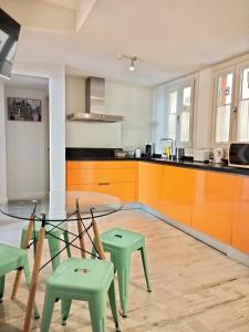 a kitchen with a glass table and two green chairs at Street Cathedral Sevilla in Seville