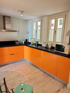 a kitchen with orange cabinets and a black counter top at Street Cathedral Sevilla in Seville