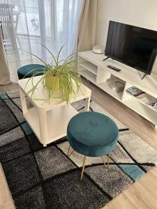 ein Wohnzimmer mit einem Tisch, einem Stuhl und einem TV in der Unterkunft Les Bains Studio Vue Mer in Pléneuf-Val-André