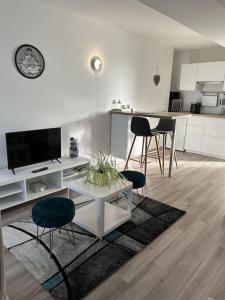ein weißes Wohnzimmer mit einem Tisch und Stühlen in der Unterkunft Les Bains Studio Vue Mer in Pléneuf-Val-André