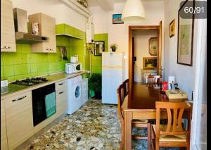 Una cocina con una mesa y un refrigerador blanco. en Pang's Guesthouse, en Mestre
