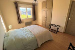 ein Schlafzimmer mit einem weißen Bett und einem Fenster in der Unterkunft Maison avec véranda - Gîte de l'Arbrisseau in Rethel