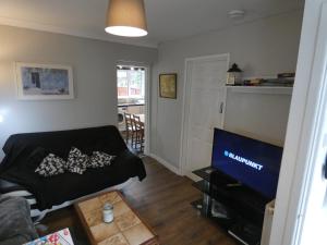 uma sala de estar com um sofá e uma televisão em 3 Bedroom House for Brecons and Bike Park Wales em Merthyr Tydfil
