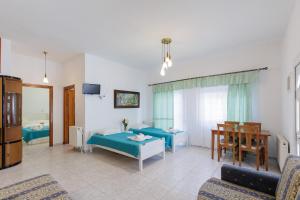 a living room with two beds and a table at Villa Romantika in Chrysi Ammoudia