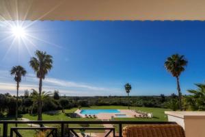 a view from the balcony of a resort with a pool and palm trees at Colina Verde Resort in Moncarapacho