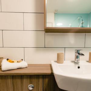 a bathroom with a sink and a mirror and a towel at May Isle Apartment in Anstruther