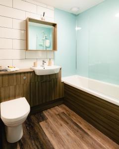 a bathroom with a toilet and a sink and a tub at May Isle Apartment in Anstruther