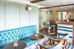 a restaurant with a blue bench and tables at The Old Stocks Inn in Stow on the Wold